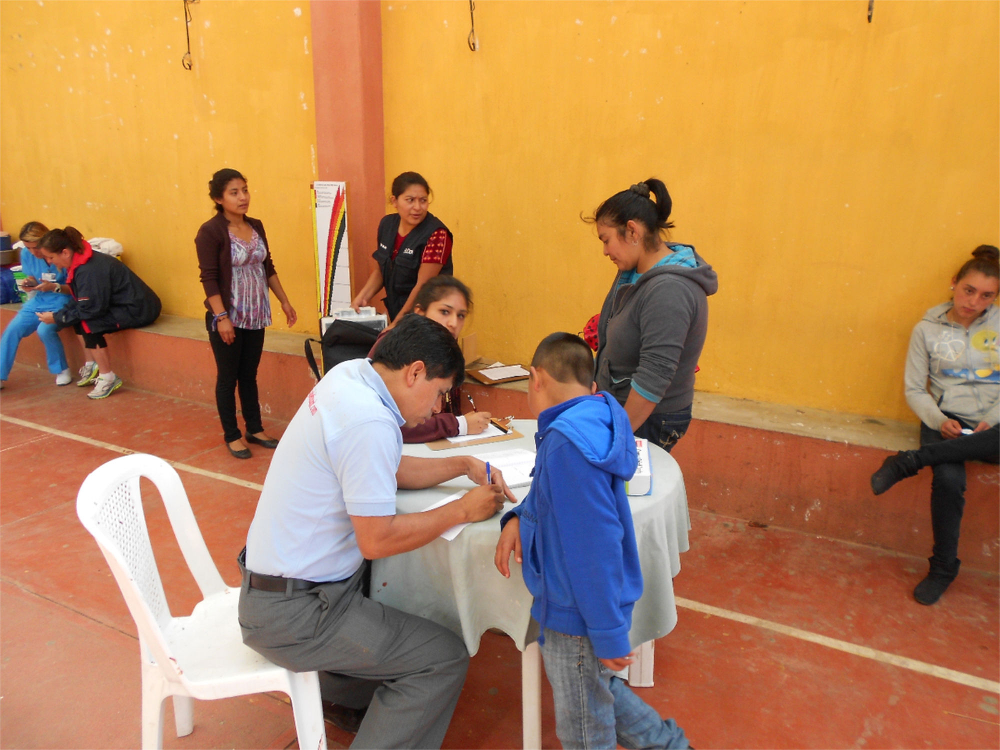 People sitting at a table waiting outside the community nursing clinic